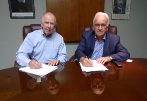 Signing the agreement is (left) APC Chairman Donald J Keehan, and (right) Peter Huni, President of HUNI + CO